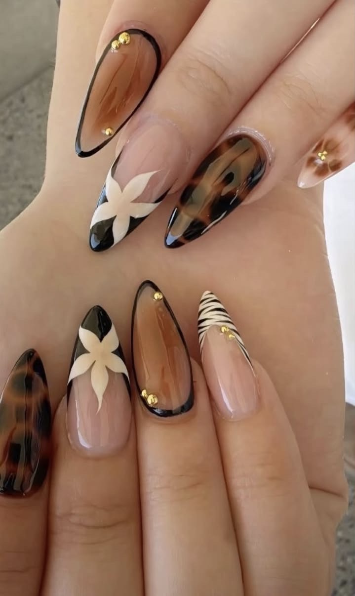 Referencia de uñas con animal print, flores y contornos oscuros