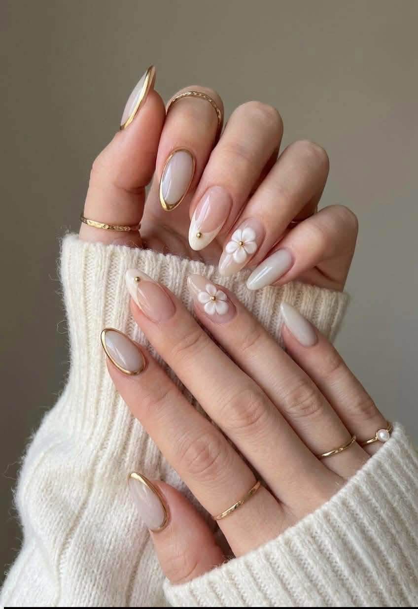 Referencia de uñas con flores blancas y detalles dorados